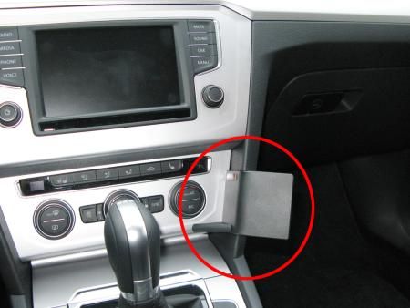 Instrumentbräda med skärm och kontroller, samt en vinklad förvaringsficka.