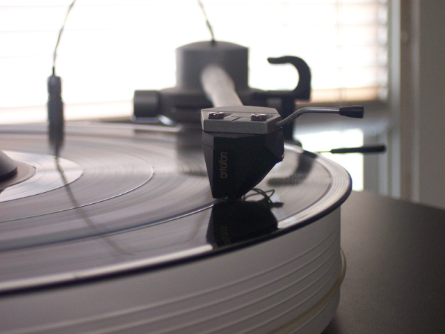 En skivspelare med en Ortofon 2M Black pickup på en snurrande vinylskiva.