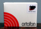 Ortofon 2M Red Verso MM-pickup En vit förpackning med röd cirkulär grafik och produktnamnet Ortofon 2M Red Verso.