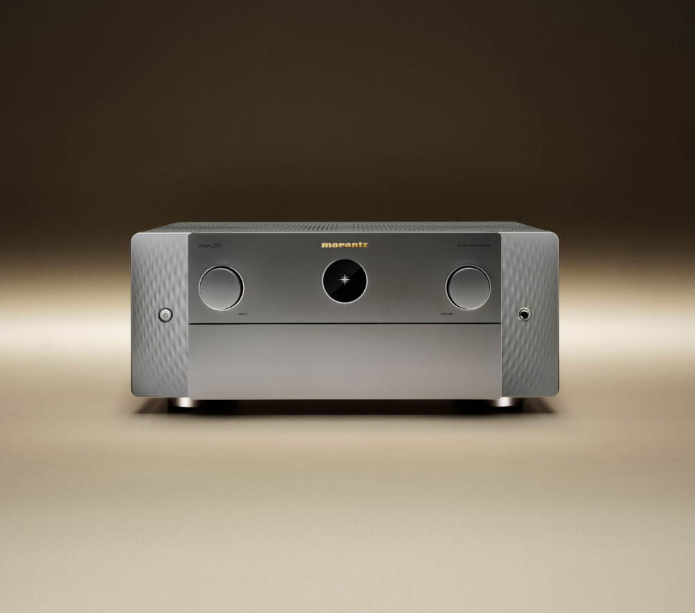 En silverfärgad hemmabioförstärkare med två reglage och en knapp.