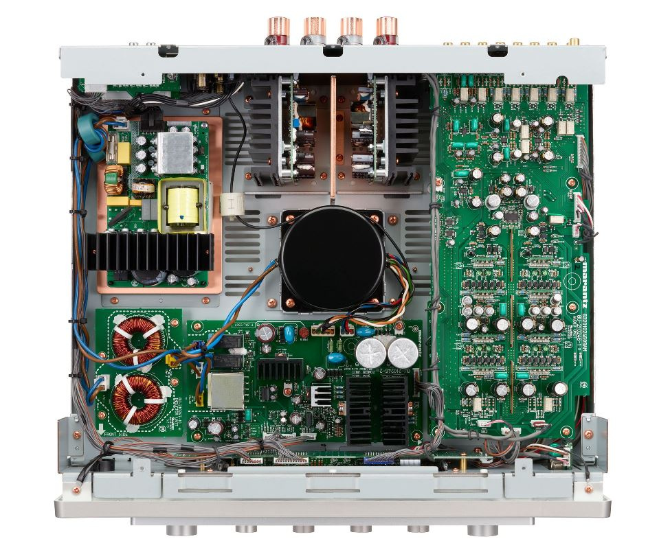 Inuti förstärkaren syns kretskort, komponenter och kablar.