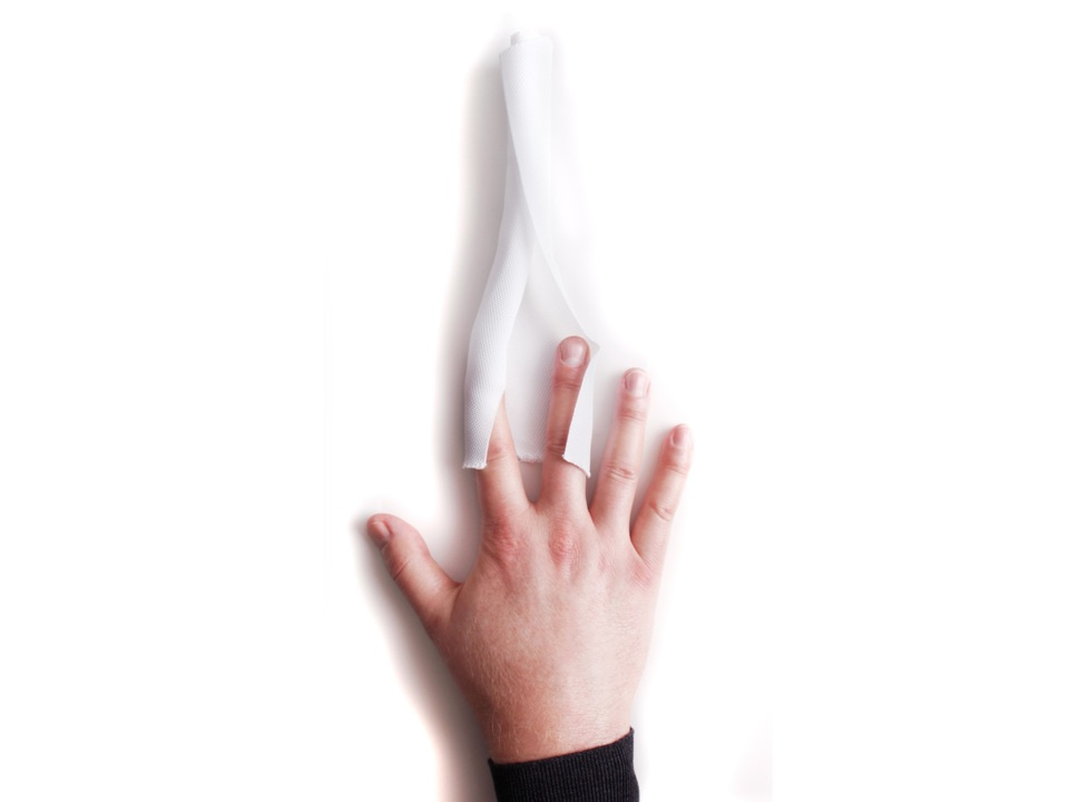 En hand som håller i en vit kabelstrumpa.