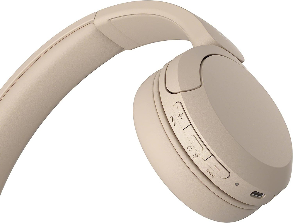 Trådlösa on-ear hörlurar i beige med kontrollknappar och mikro-USB-port.