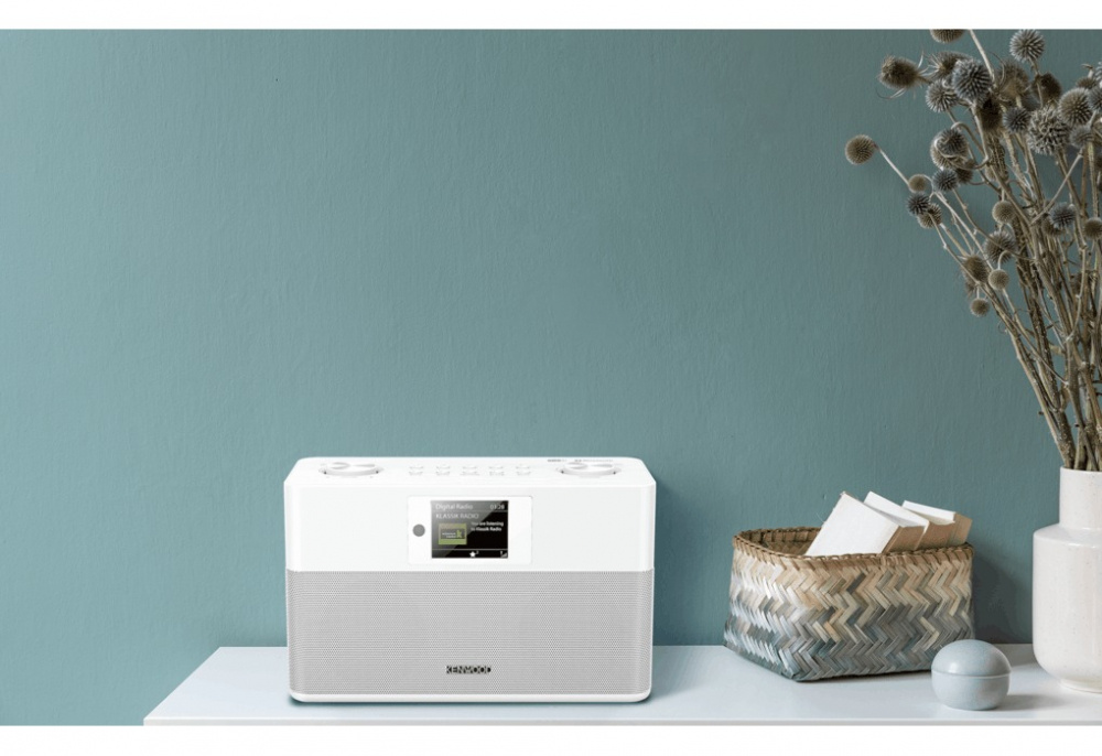 Vit kompakt radio med DAB+ och Bluetooth, placerad på ett bord.
