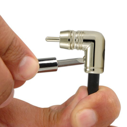 En person håller en vinklad RCA-kontakt och en skruvmejsel.