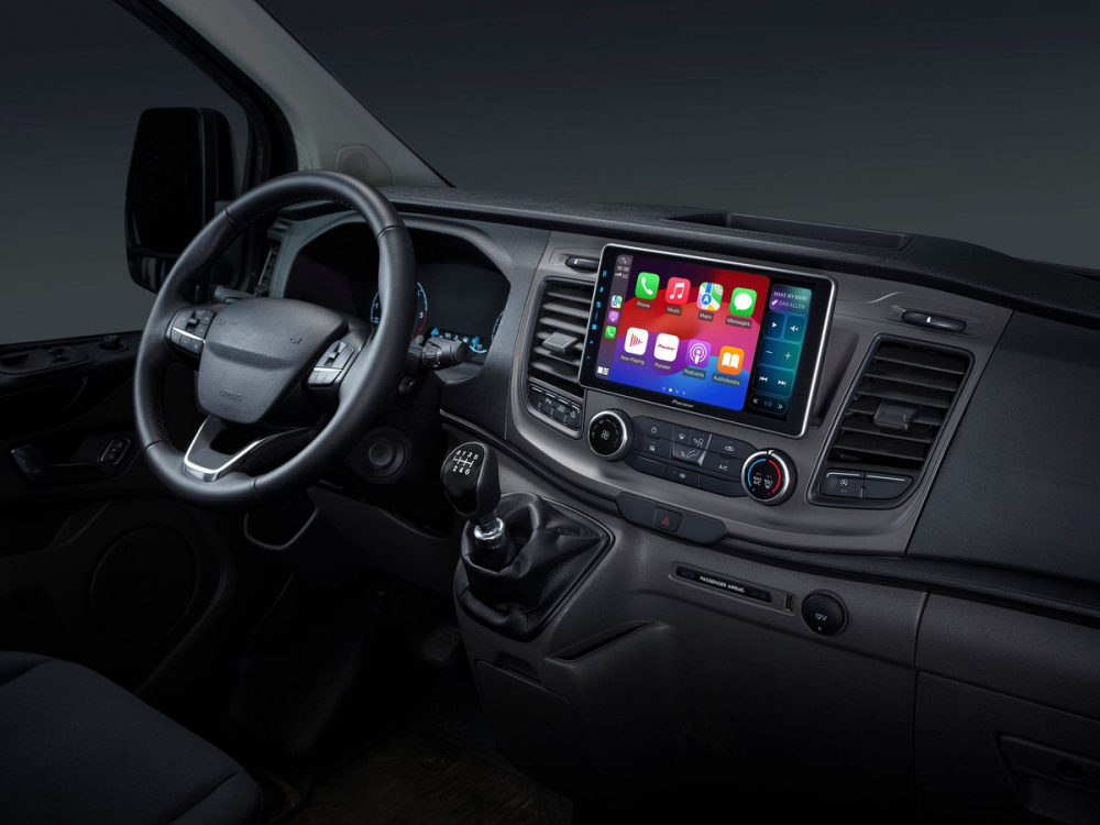 Bilden visar en bilinteriör med en stor bilstereo och växelspak.