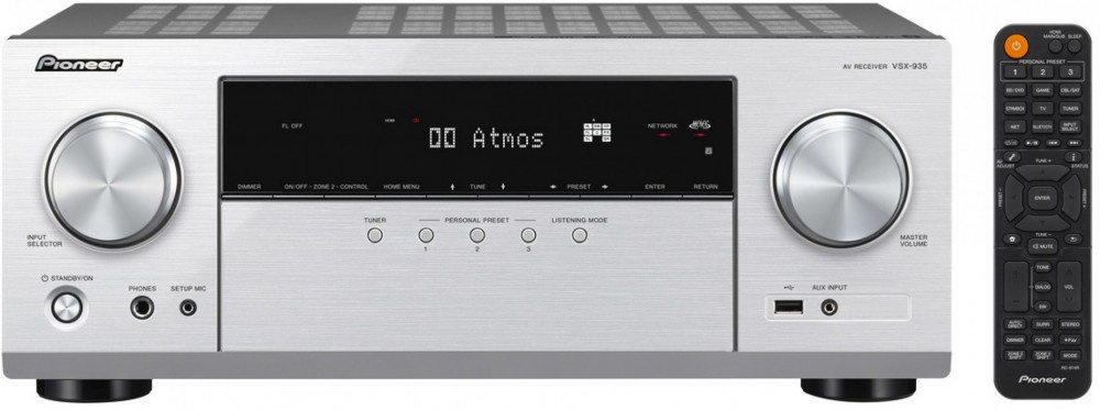 Hemmasystemförstärkare i silver med flera kontroller och fjärrkontroll.