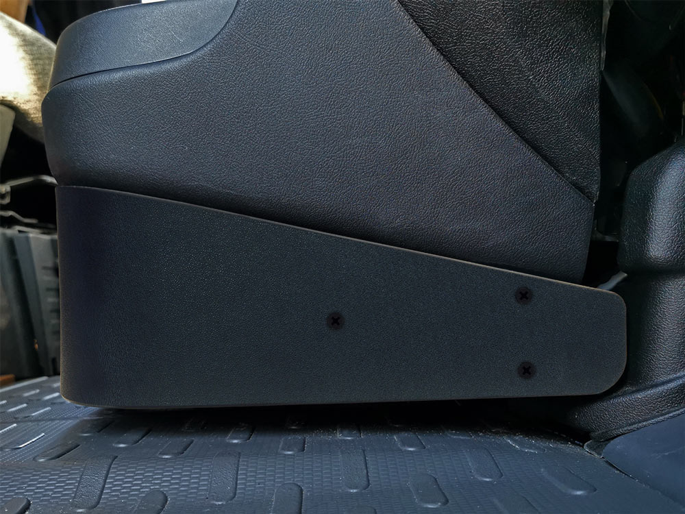 Svart plastdel fäst på sitsens sida, del av baslåda för Fiat Ducato 3.