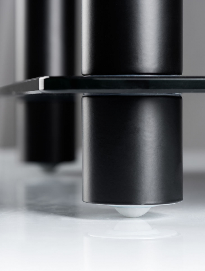 En närbild av en svart, stilren mediabänk med runda ben.