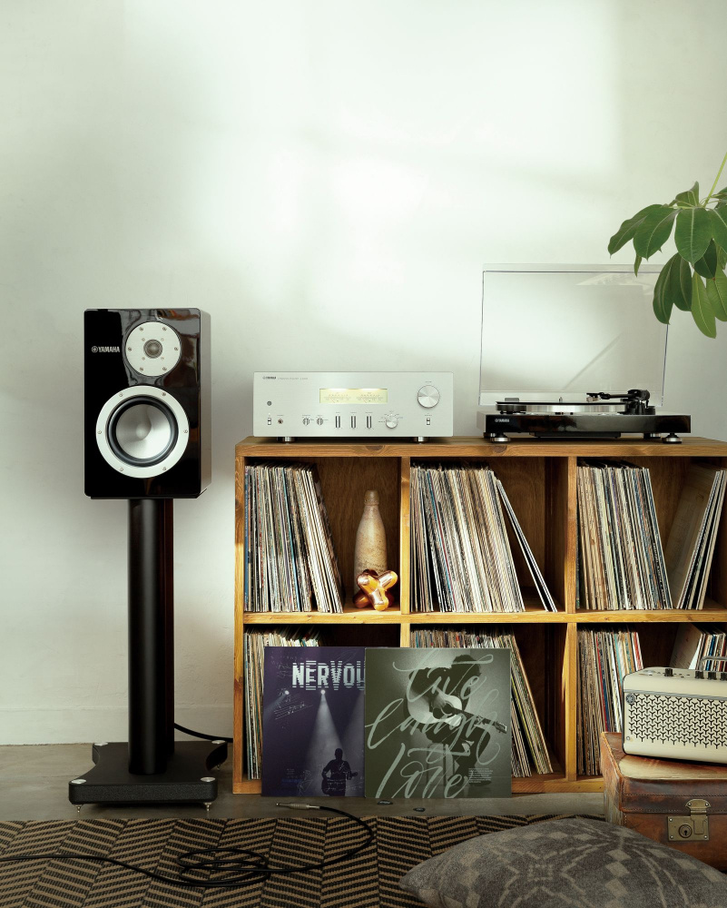 En retroinspirerad förstärkare och vinylskivor i en mysig miljö.