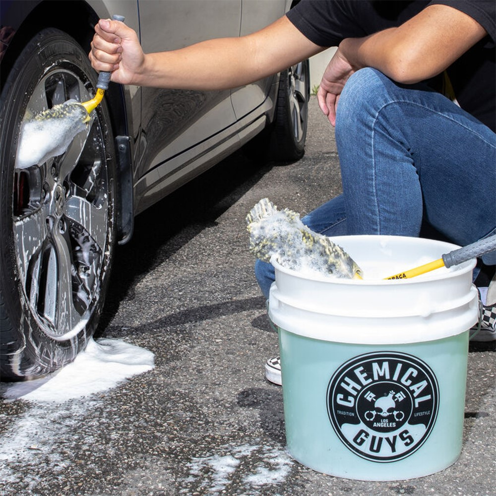 Två hjulborstar används för att rengöra en bils fälgar.