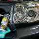 Chemical Guys Headlight Restorer And Protectant strålkastarrengöring, 473 ml En flaska strålkastarrengöring bredvid en bilstrålkastare.