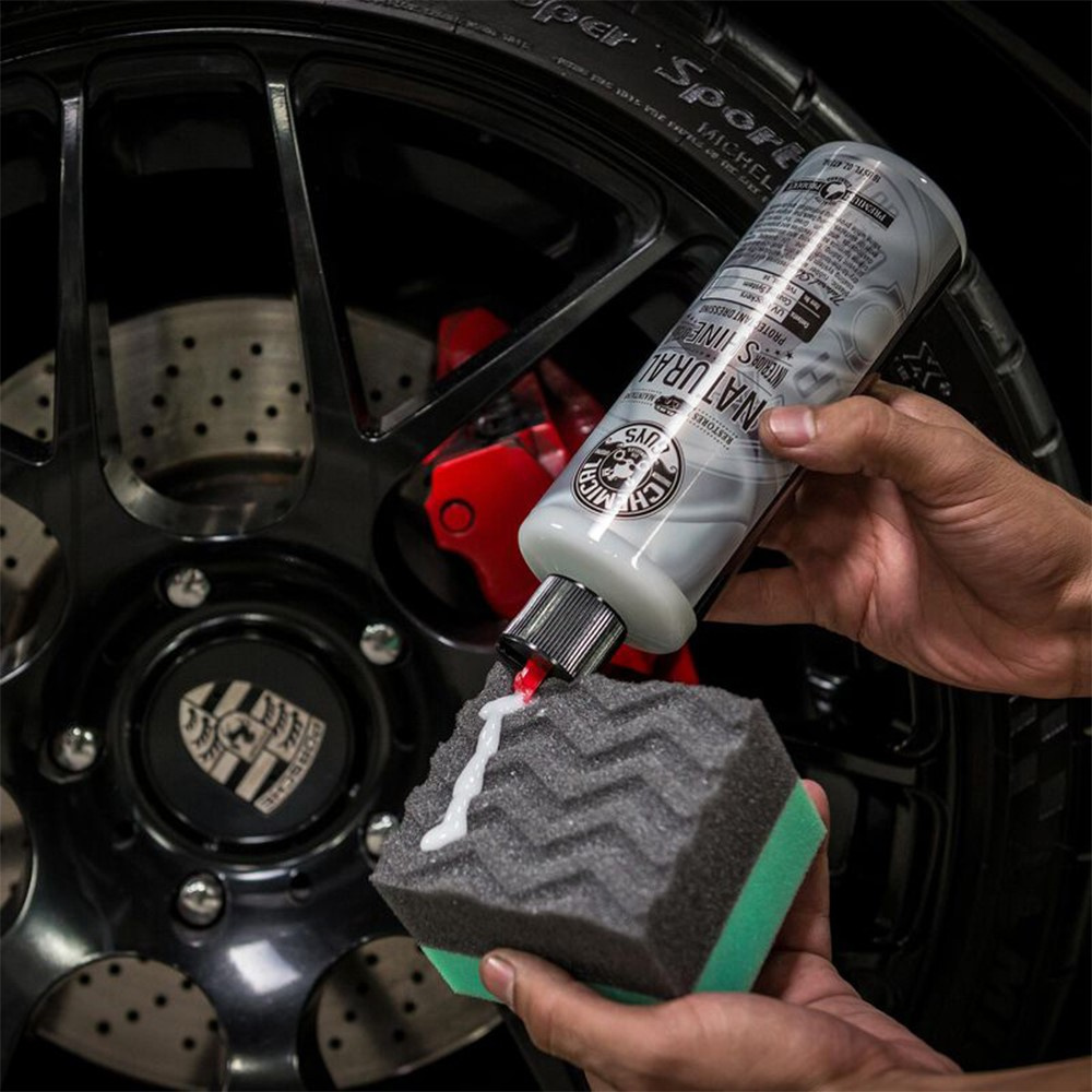 En flaska bilvårdsprodukter appliceras med en svamp.