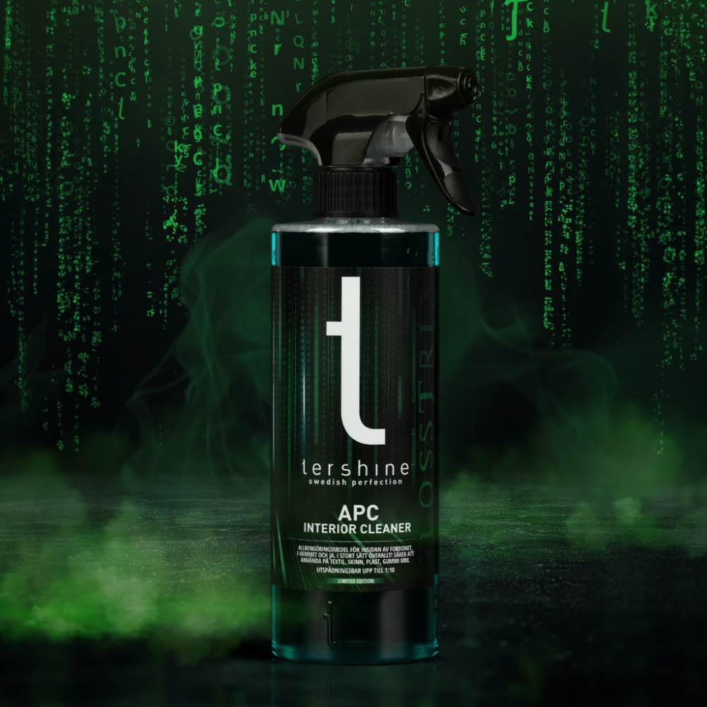 En svart sprutflaska med grön etikett och minimalistisk design på en mörk bakgrund.