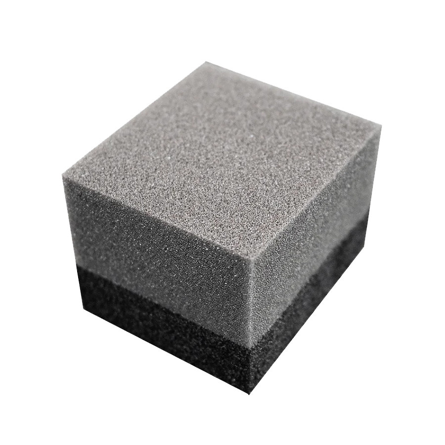 En fyrkantig, mörkgrå applikator med skumstruktur.