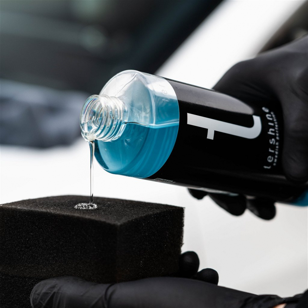 Flaska med blå vätska hälls på en svamp.