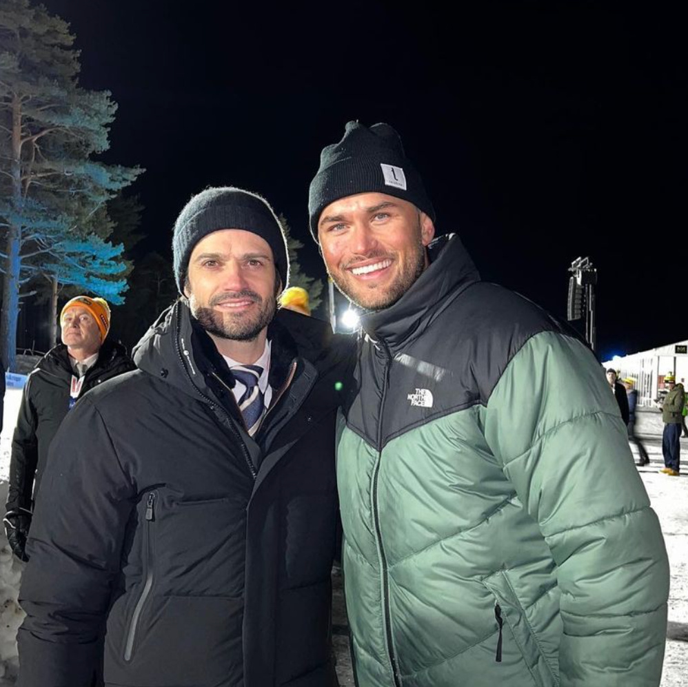 Två män i vinterkläder står tillsammans utomhus i snöigt landskap.