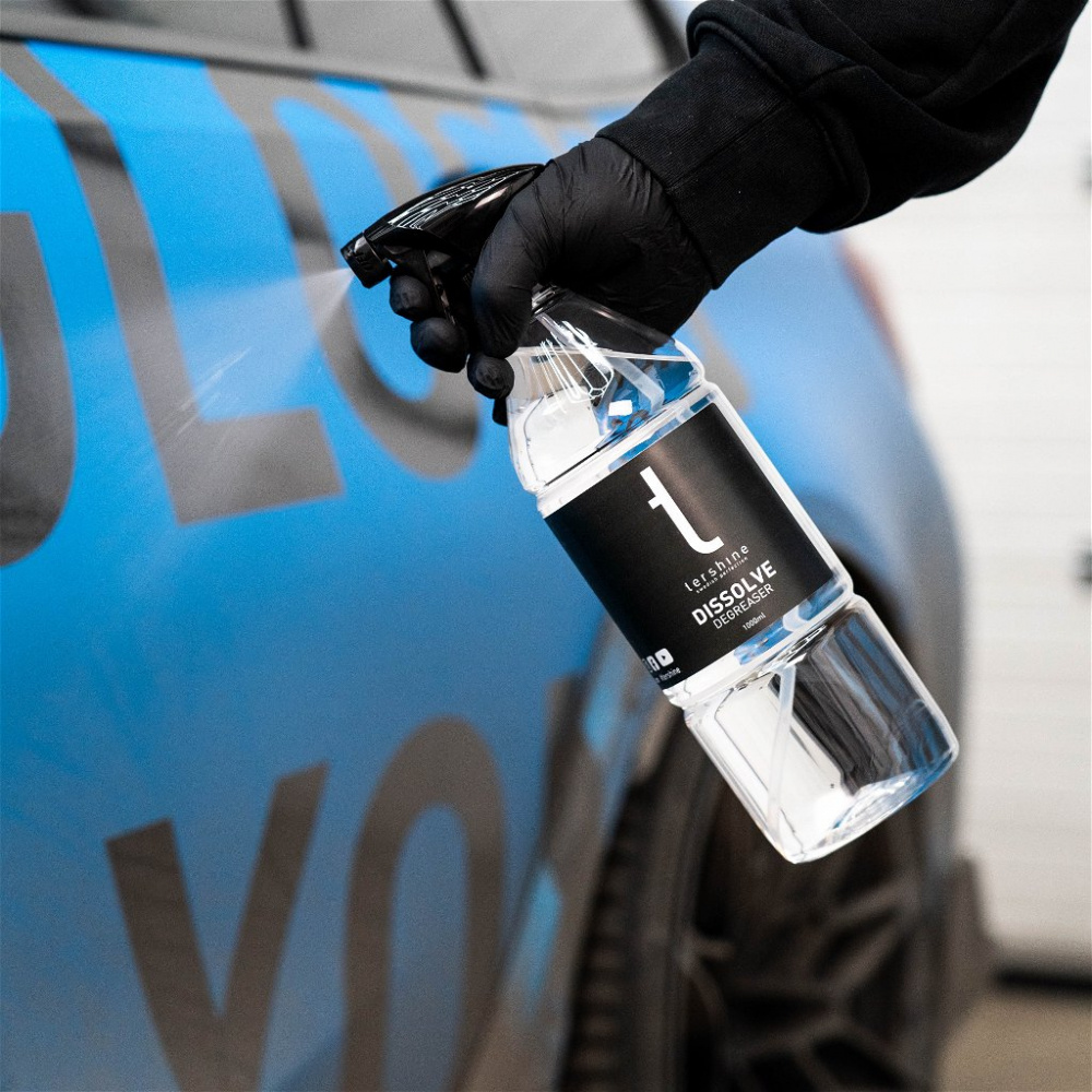 En hand håller en sprayflaska med avfettning.