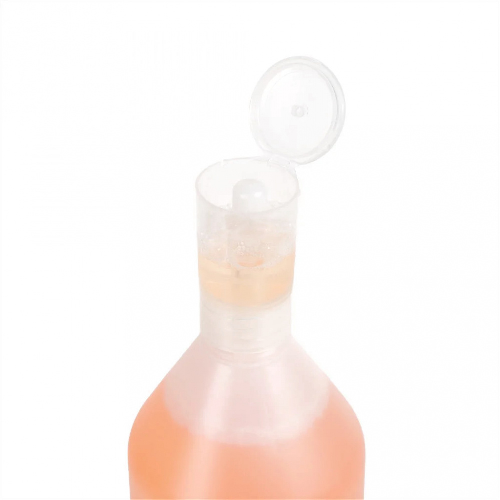 Flaska med doseringsmått och en genomskinlig lock. Innehållet är rosa.