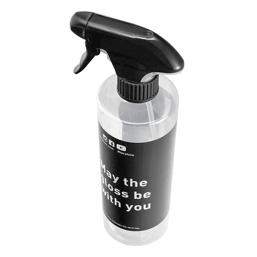 En transparent sprayflaska med svart sprayhuvud och text.