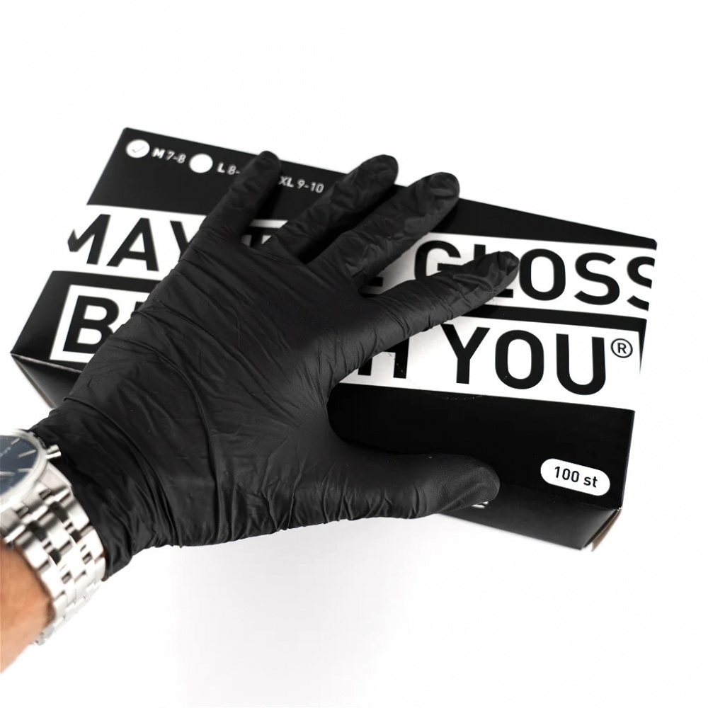 Svarta nitrilhandskar i en låda, hand med handske syns på bilden.