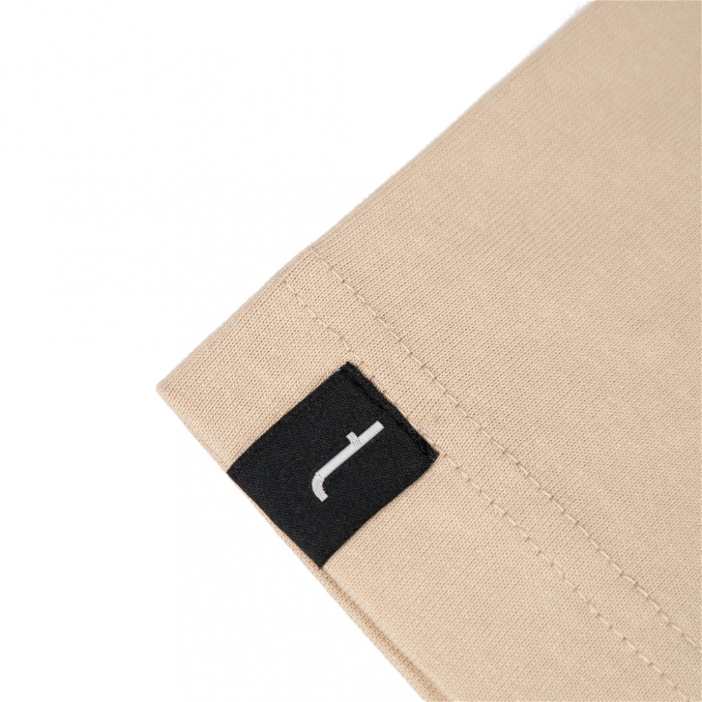 Beige oversized t-shirt med svart etikett.