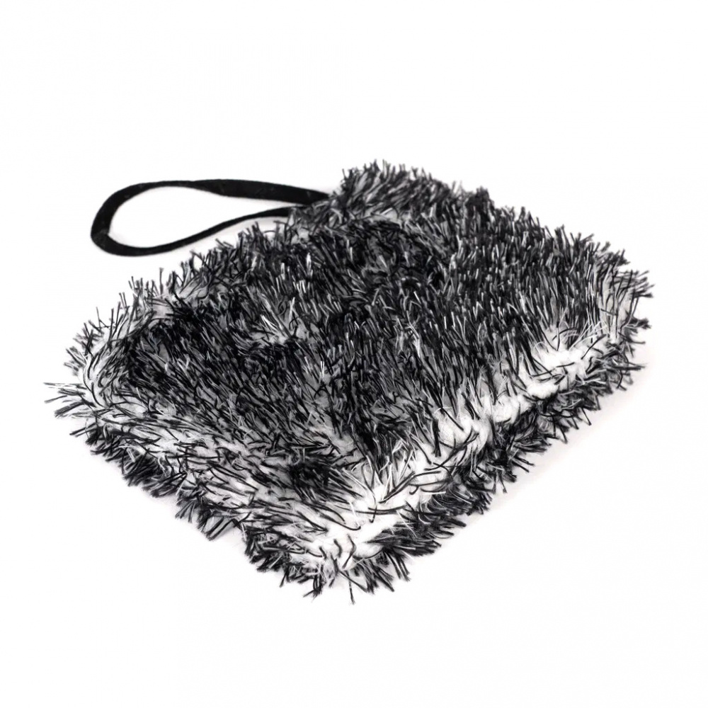 En tvättpad med en fluffig yta och en handtag. Färgerna är svart och vit.