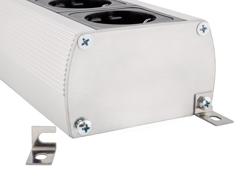 En metallisk strömskena med tre uttag och fästen.