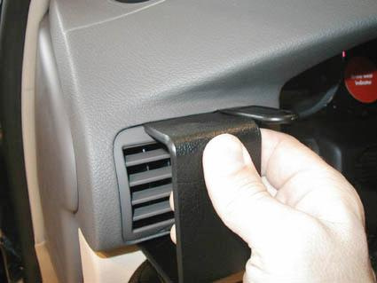 Helt enkelt en hand som håller i en del av bilens ventilationssystem.