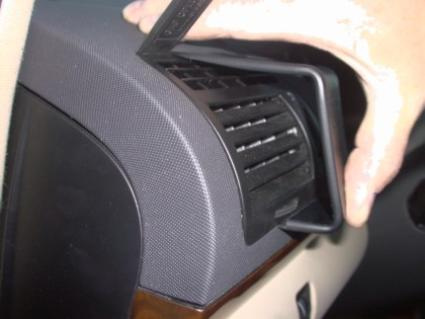 En hand visar en luftventil på insidan av en bil.