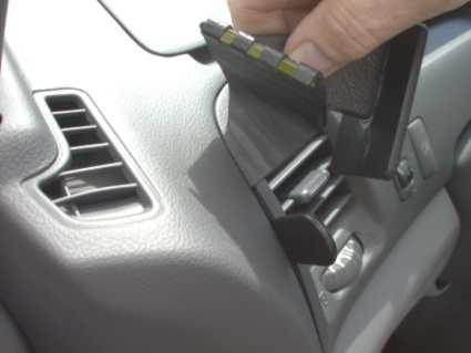 En hand håller i en del av instrumentbrädan i en Toyota Previa.