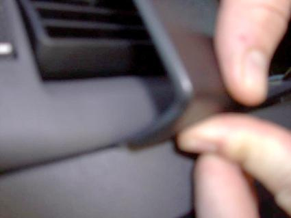 Visar en hand som håller i en del av inredningen i en Ford Transit Connect.