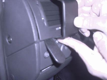 En hand justerar en spak eller knapp på Opel Meriva 03-10.