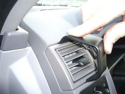 En hand justerar en luftventil i en bilinteriör.