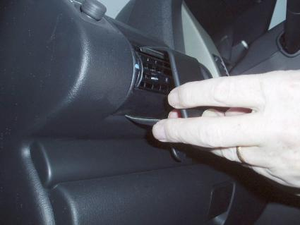 Hand som justerar luftventil i en bilinteriör.