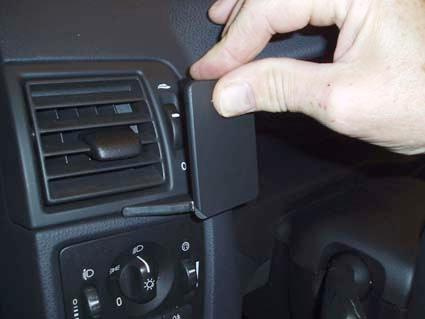 En hand justerar en del av bilens inredning, troligtvis en ventil eller kontrollpanel.