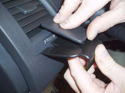 Två svarta luftkanalsluckor tas bort från instrumentpanelen.