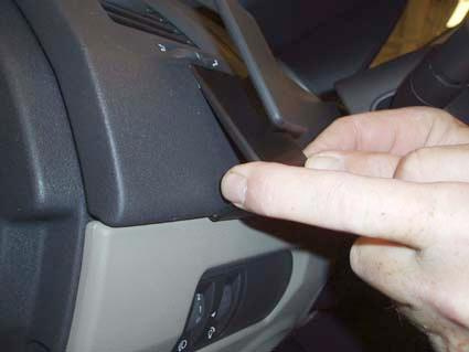 En hand pekar på en del av instrumentpanelen i en Renault Mégane.