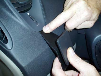 En person pekar på en del av bilinteriören i en Renault Scénic.