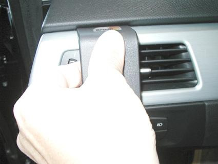 En hand trycker på en knapp nära ventilationsöppningen i en BMW.