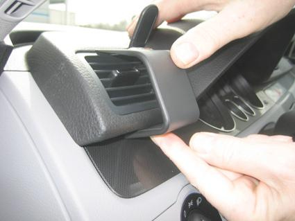 En hand justerar en del av instrumentpanelen i en Volkswagen Passat.