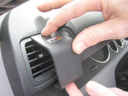 En person monterar ett tillbehör på luftventilen i en Volkswagen Passat.