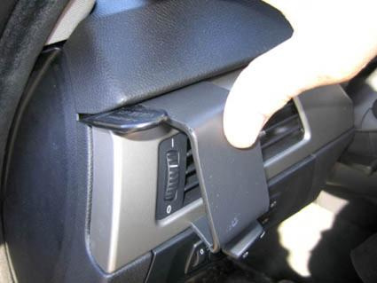 En hand justerar en del av inredningen i en BMW E90/E91/E92/E93.