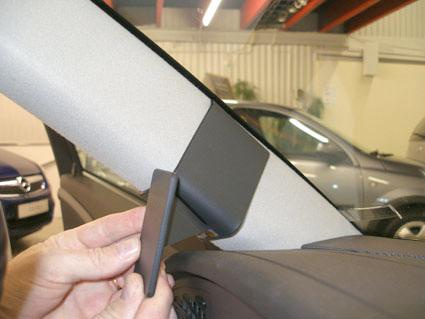 En hand som håller en del av inredningen för en Saab 9-5.