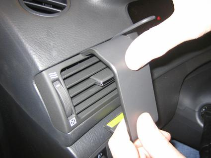 En hand justerar en del i bilen nära luftventilen.