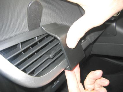 En hand som justerar en ventilationsgrill i en Peugeot 207.