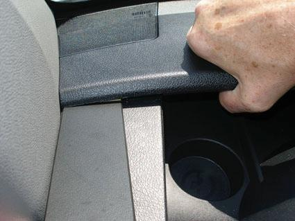 En hand som greppar en del av instrumentbrädan i en Volkswagen Crafter.