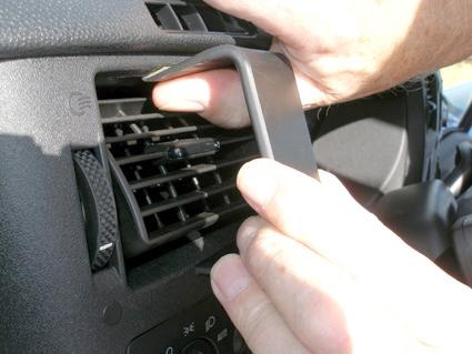 En person byter ett luftutlopp i en Ford Transit 07-13.