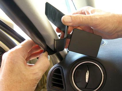 Händer som justerar en del av fordonsinteriör, troligtvis spegelinstallation.