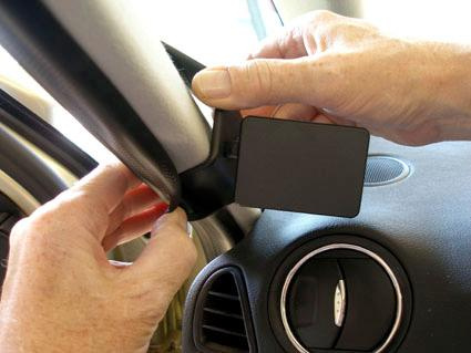 Klassisk bilinteriör med fokus på montaget av en komponent vid A-stolpen.